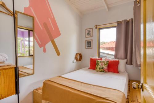 a small bedroom with a bed and a window at Selina Jaco in Jacó