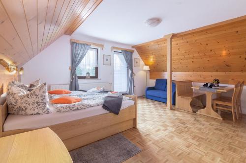 ein Schlafzimmer mit einem großen Bett und einem Tisch in der Unterkunft Apartments Ukanc in Bohinj