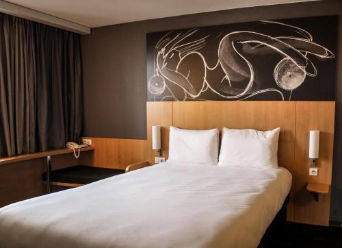 ein Hotelzimmer mit einem Bett und einem Gemälde an der Wand in der Unterkunft Ibis Saint-Genis-Pouilly Genève in Saint-Genis-Pouilly