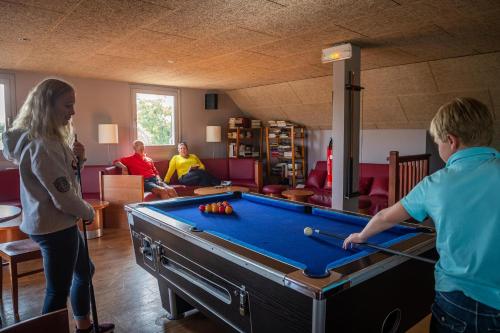 un groupe de personnes jouant au billard dans une pièce dans l'établissement Les Prairies de la Mer - Baie de Somme, à Favières