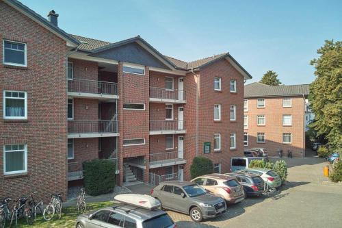 ein Backsteinapartment-Gebäude mit Autos auf einem Parkplatz in der Unterkunft Haus Roland Wohnung 11 in Zinnowitz