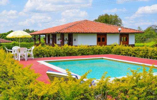 a villa with a swimming pool and a house at Finca Rionegro Rancho La Soledad in Montenegro