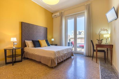 une chambre avec un lit, un bureau et une fenêtre dans l'établissement Al Porto Di Cagliari, à Cagliari