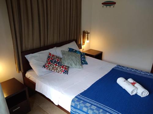 a bedroom with a bed with pillows on it at Apto Pipa Beleza Spa Resort in Pipa