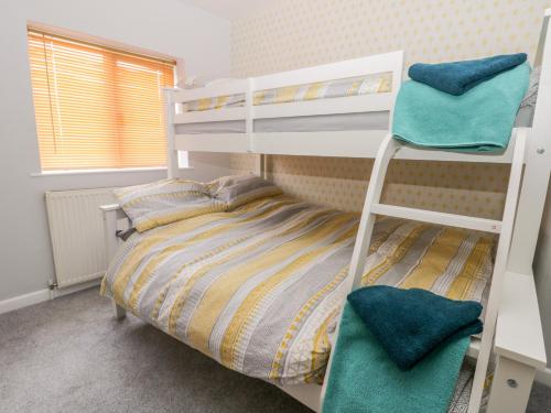 מיטה או מיטות קומותיים בחדר ב-Scarborough Cottage