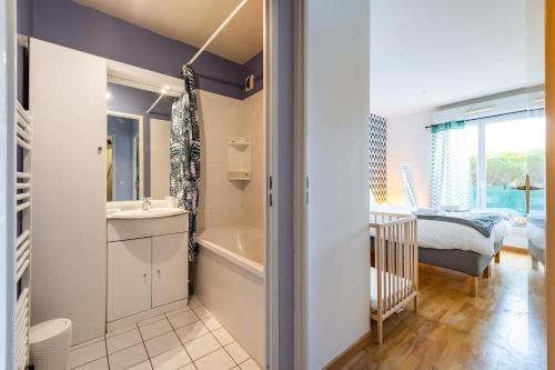 une salle de bain avec un lavabo, une baignoire et un lit dans l'établissement Magnifique appartement 7 Pers proche gare, à Lognes