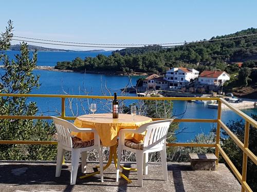 a table with a bottle of wine sitting on a balcony at Extra Spacious Seaview Apartments close to the beach, with large terraces and FREE WI-FI & AC & BBQ & parking space in Sali