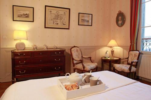 a bedroom with a bed with a dresser and chairs at Les Chambres de Mathilde in Angers