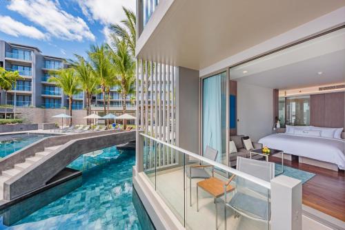 Cette chambre offre une vue sur une piscine et un lit. dans l'établissement Oceanfront Beach Resort - SHA Extra Plus, à Patong Beach