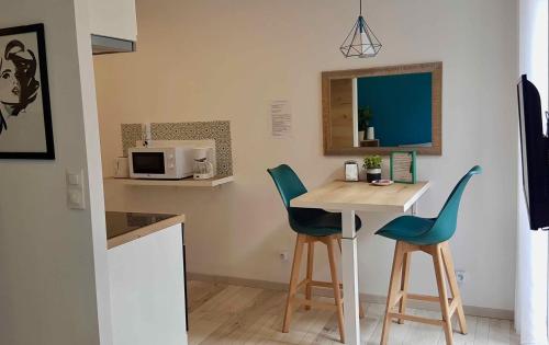 een kleine keuken met een tafel en 2 stoelen bij Studio La Touvière in Évian-les-Bains
