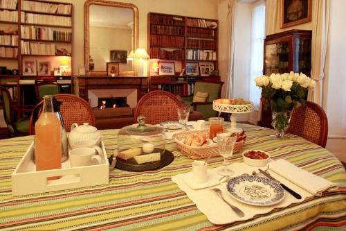 a dining room table with a table set with food at Les Chambres de Mathilde in Angers