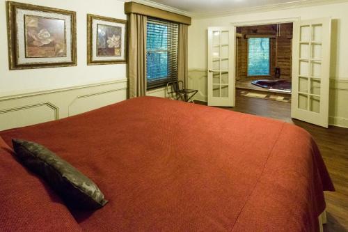 a bedroom with a large bed with a red blanket at Forrest Hills Mountain Resort in Dahlonega