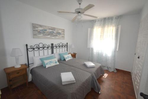 a bedroom with a bed and a ceiling fan at Villa Bonita en Aguilas Murcia con piscina privada in Águilas