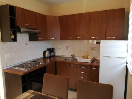 a kitchen with wooden cabinets and a white refrigerator at Christian in Mali Lošinj