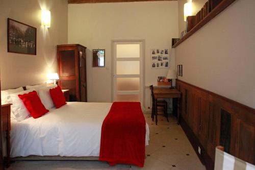 a bedroom with a bed with red pillows and a desk at Les Chambres de Mathilde in Angers