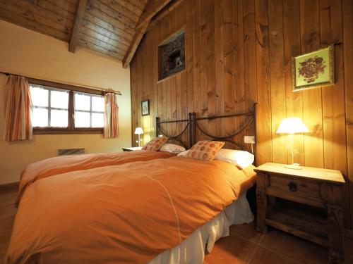 1 dormitorio con 1 cama en una habitación con paredes de madera en Los Tres Albares, en Lardiés
