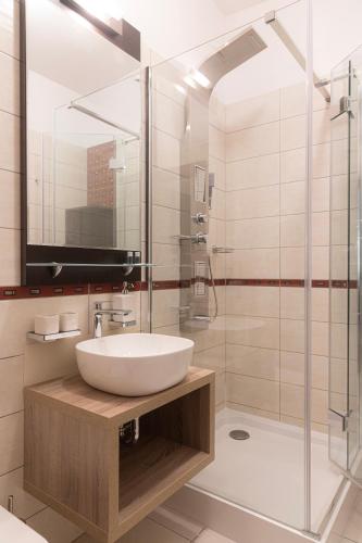 a bathroom with a sink and a glass shower at Bazilika alatt Panzió in Esztergom