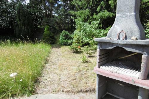 un horno de piedra sentado en un jardín con un camino en Ruegen_Fewo 68, en Natzevitz