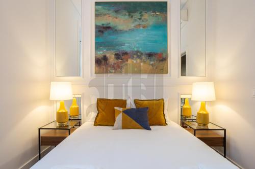 a bedroom with a white bed with two lamps at Morgan-Jupiter Apartments in Lisbon