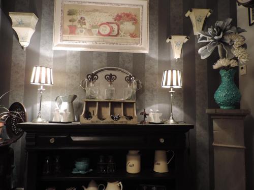 une pièce avec une étagère où sont rangées des théières et des lampes dans l'établissement Villa Des Hortensias, à Paimpol