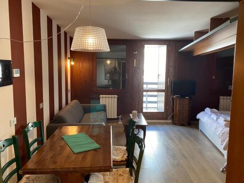 ein Wohnzimmer mit einem Tisch und einem Sofa in der Unterkunft Monolocale Cielo Alto in Breuil-Cervinia