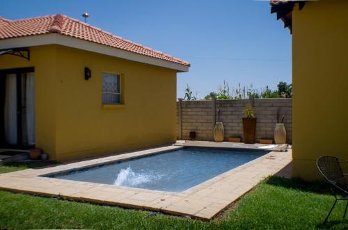 a swimming pool in a yard next to a house at Seroloana Guest House in Rustenburg