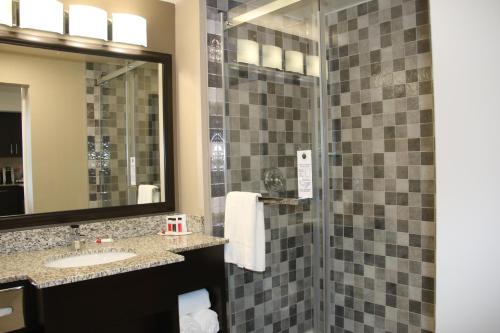 a bathroom with a shower and a sink and a mirror at Super 8 by Wyndham Canmore in Canmore