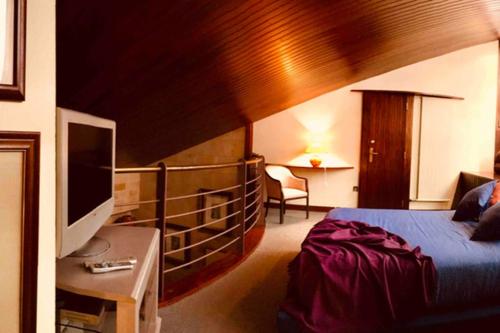 um quarto de hotel com uma cama e uma televisão em Chalet Individual con bodega, en el corazón de La Rioja em Gimileo