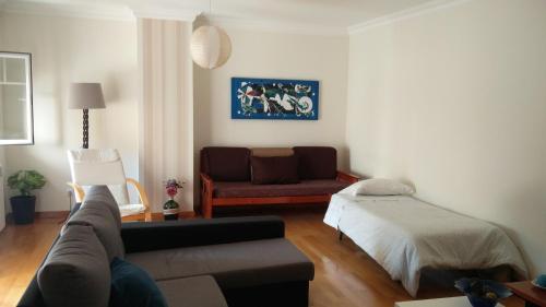 salon z kanapą i łóżkiem w obiekcie Apartamento Central w mieście Torres Vedras
