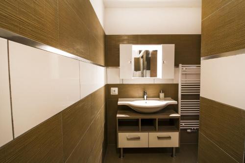 La salle de bains est pourvue d'un lavabo et d'un miroir. dans l'établissement Apartment Kogelblick Zell am See - Kaprun, à Piesendorf