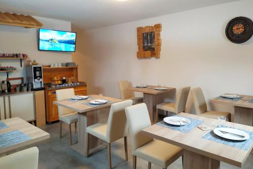 a restaurant with wooden tables and chairs and a tv at Plitvice Streaming in Prijeboj