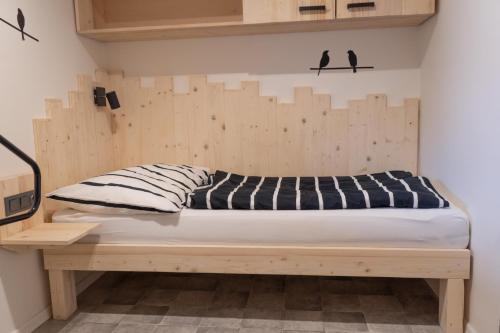 a bed in a room with a wooden wall at Apartmány pod Ještědem in Liberec