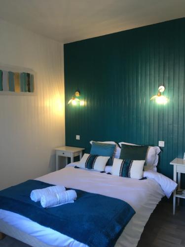 a bedroom with a large bed with a green wall at Hôtel Aux Vendanges de Bourgogne in Paray-le-Monial