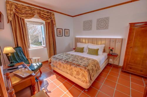 1 dormitorio con 1 cama, 1 silla y 1 ventana en El-Rei Dom Manuel Hotel en Marvão