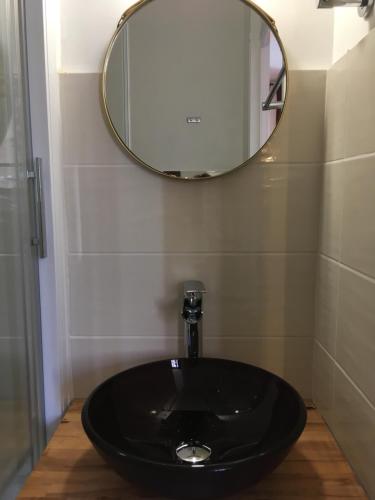 a bathroom with a black sink and a mirror at Hôtel Aux Vendanges de Bourgogne in Paray-le-Monial
