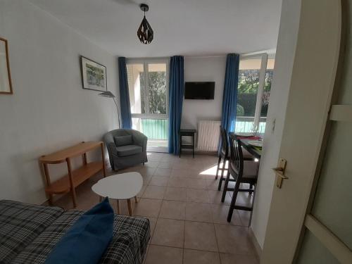 un salon avec un lit, une table et des chaises dans l'établissement MARSEILLE CALANQUES, à Marseille