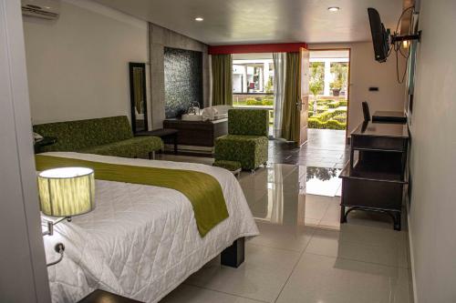 une chambre d'hôtel avec un lit et un piano dans l'établissement Hotel María Dolores San Luis Potosí, à San Luis Potosí