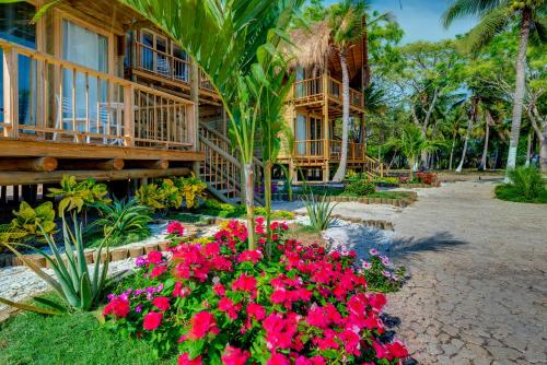 a resort with flowers in front of a building at Hotel Isla del Encanto in Baru