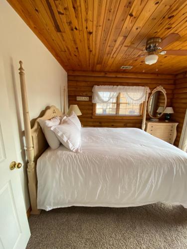 a bedroom with a white bed with a wooden ceiling at Crown Lake Resort in Horseshoe Bend