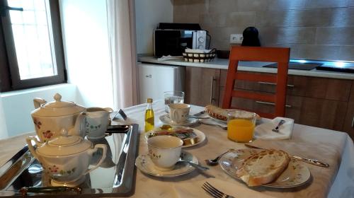 a table with a tea set with bread and toast at Alojamiento Rural La Estrella de David in Almagro