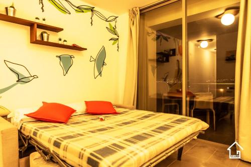 a bedroom with a bed with red pillows on it at Apartamento Las Rochas in Mindelo