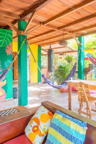 a patio with a hammock and a table and chairs at Hostal CASA COLIBRI MINCA in Minca
