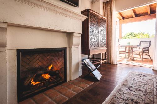 a fireplace in a living room with a table at El Encanto, A Belmond Hotel, Santa Barbara in Santa Barbara