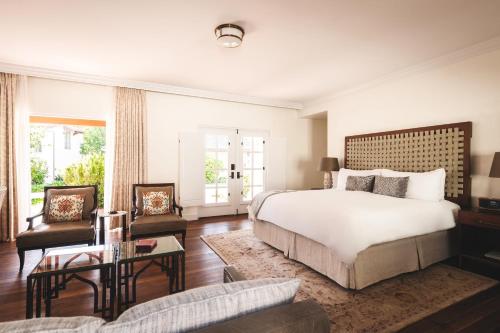 a bedroom with a large bed and a living room at El Encanto, A Belmond Hotel, Santa Barbara in Santa Barbara