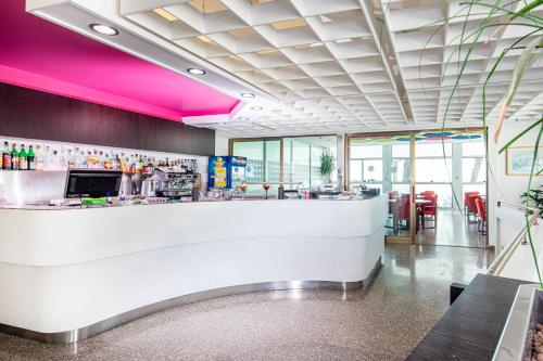 a bar in a restaurant with pink lighting at Hotel Bristol in Lignano Sabbiadoro