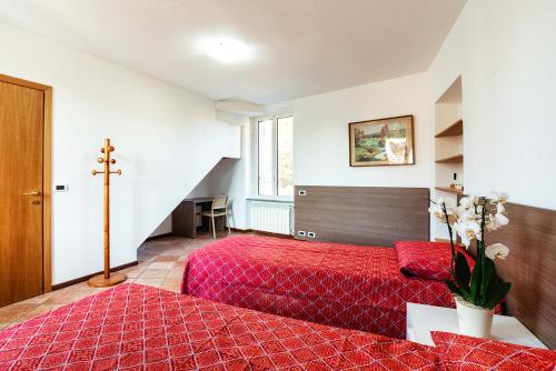 a bedroom with a red bed and a cross on the wall at Il Roseto di Marina in Lucino