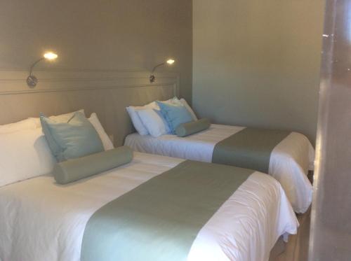 two beds in a hotel room with white and blue pillows at Club Maeva Miramar Tampico in Ciudad Madero