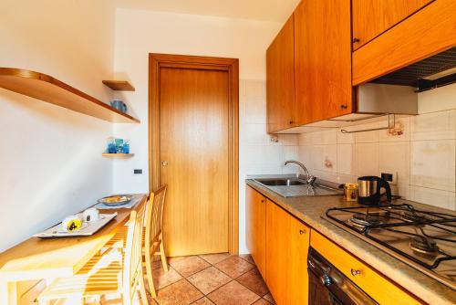 a kitchen with wooden cabinets and a counter top at Il Roseto di Marina in Lucino