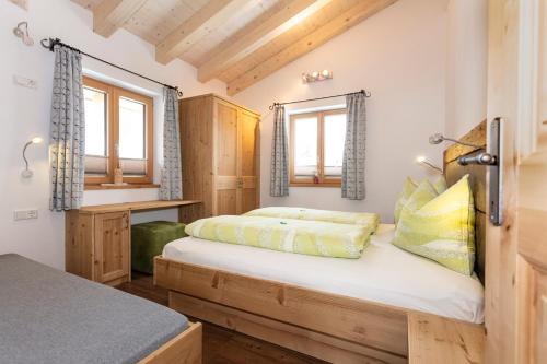 a bedroom with a bed and two windows at Ferienhaus Widauer Herzoghof in Leogang