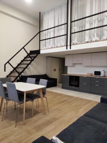 a living room with a table and chairs and a staircase at Kiev City Hotel in Kyiv